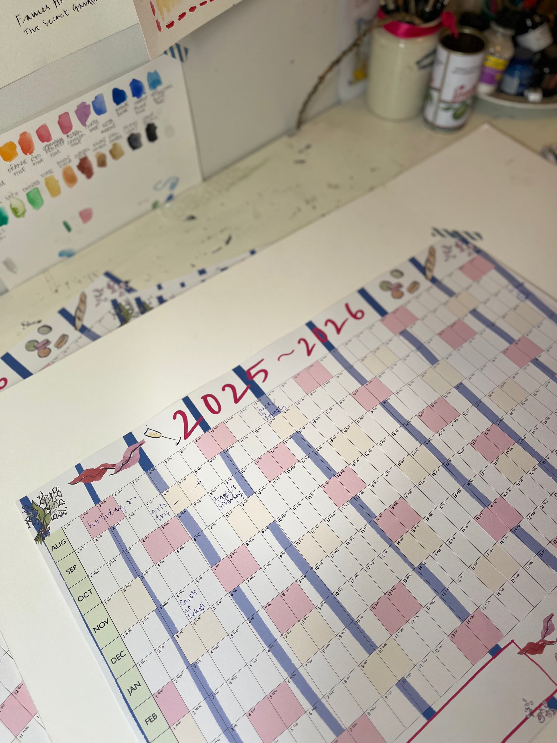 Calendar with colorful design on a desk with stationery items.